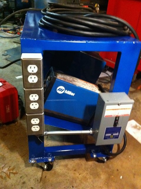 Blue welding cart with outlets and Miller logo in a workshop setting.