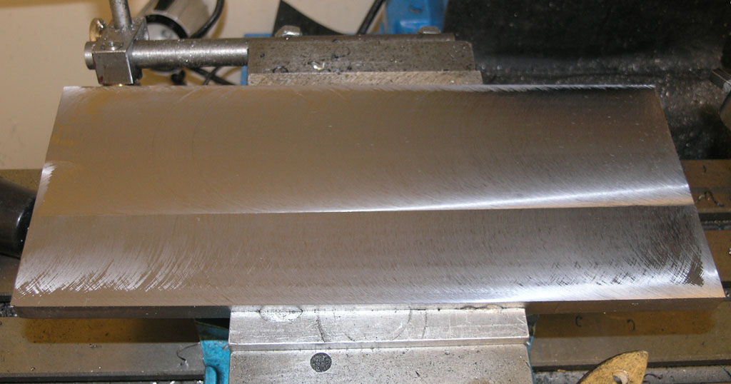 Metalworking vise with two flat metal surfaces.