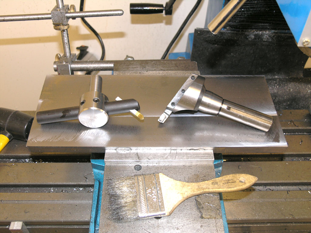 Metal working vise with tools on flat metal base and adjustable arms.