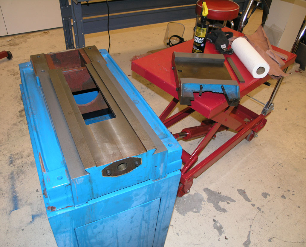 Metal object in a machine shop or garage with tools and equipment.