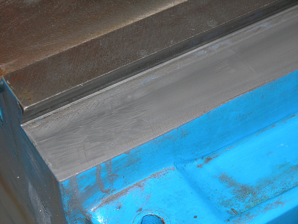 Metal surface with smooth, flat top and blue-painted bottom.