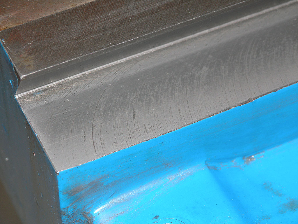Metal surface with blue stripe on dark background.