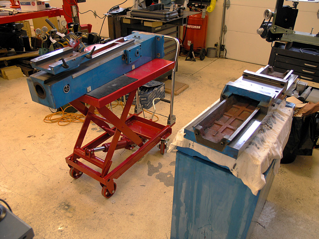 Well-lit workshop background with various machinery and tools, blue workbench in foreground with white cloth and metal channels.