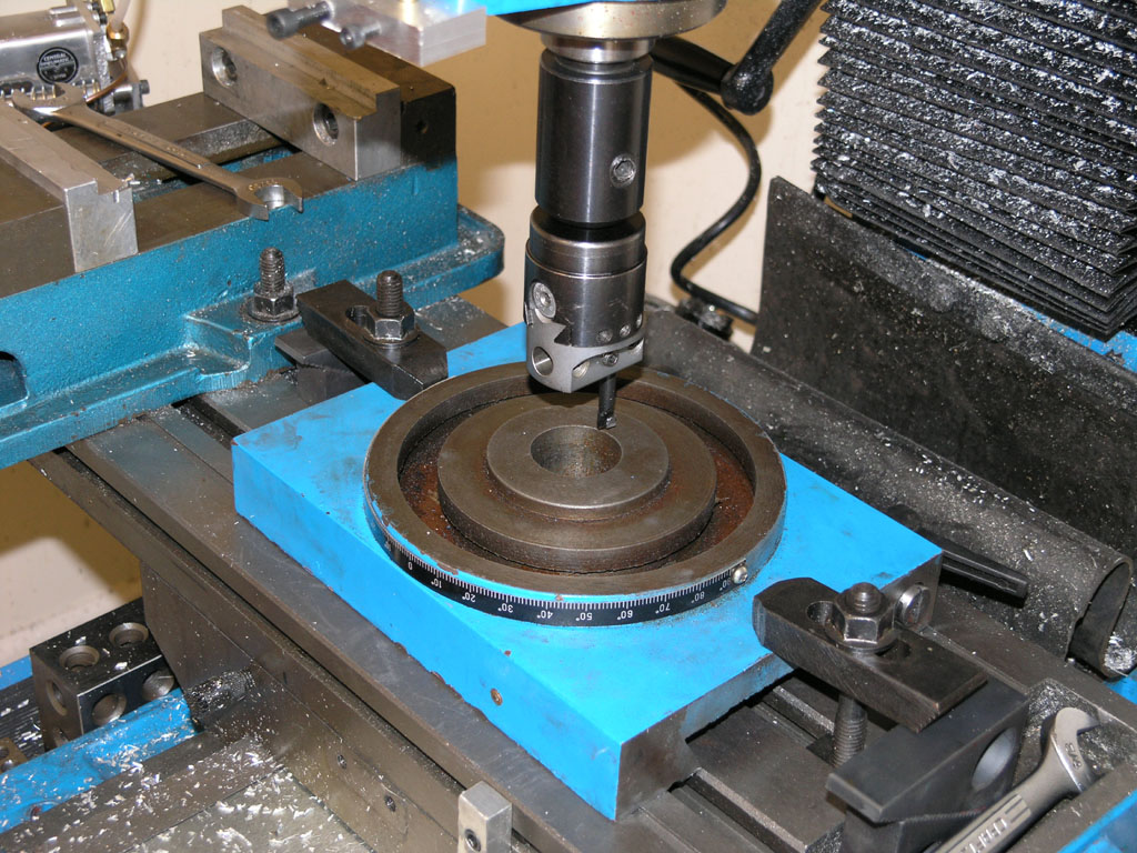 Blue and black metalworking machine with drill press, vise, and measuring instruments.