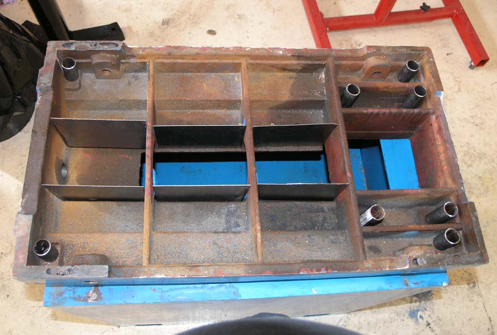 Large rusty steel metal mold with multiple compartments.