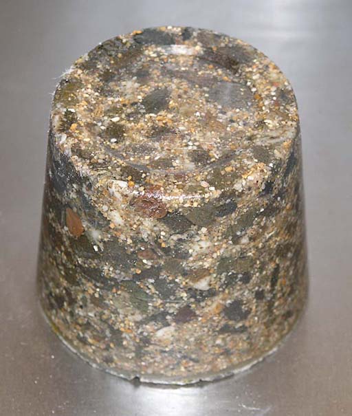 Cylindrical object with a rough, speckled surface.