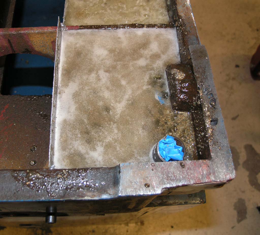 Dirty metal surface with a blue object in the corner.