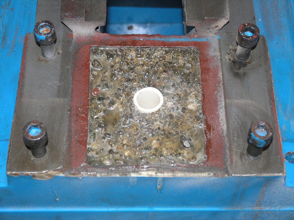 Dirty metal plate with bolts and white circular object.