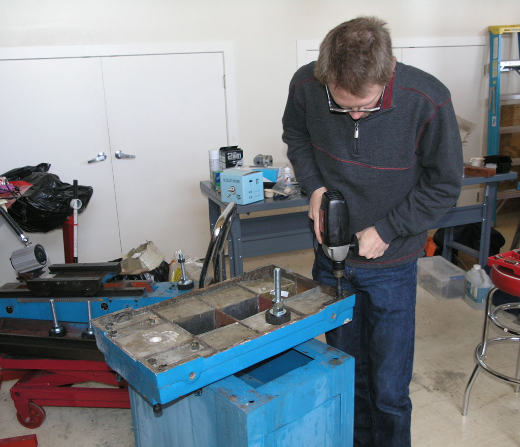 Man working in well-lit workshop with machining tools.