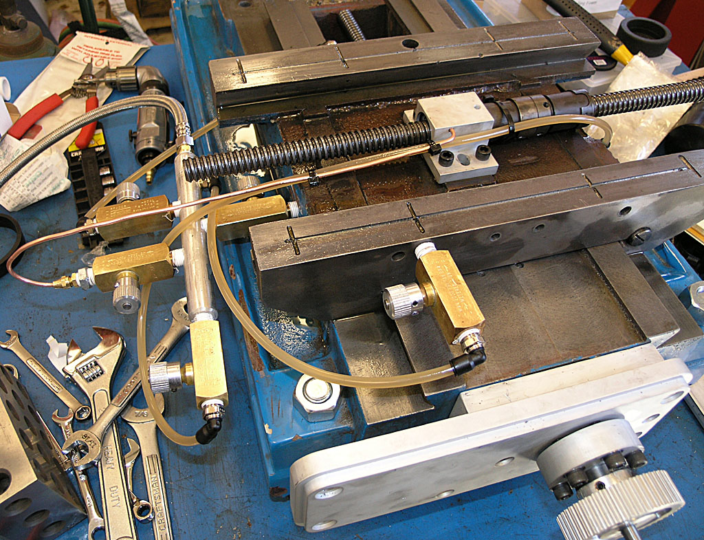 A blue workbench with tools and machinery parts, including a vice and wrenches.