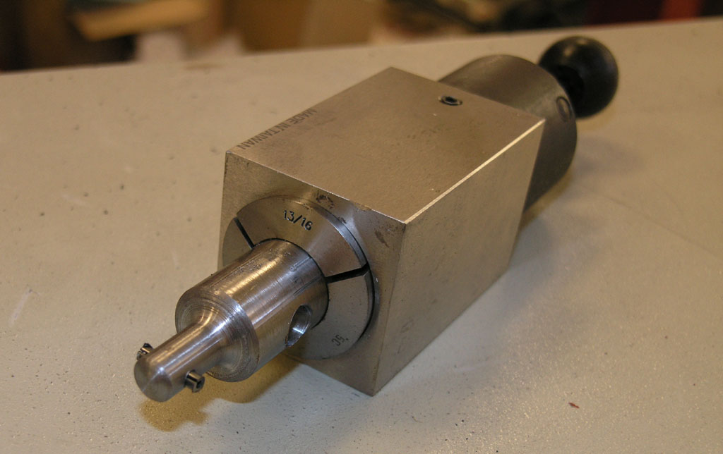 Metal object with cylindrical shaft, square base, and rounded knob, featuring engraved text including "13/16".