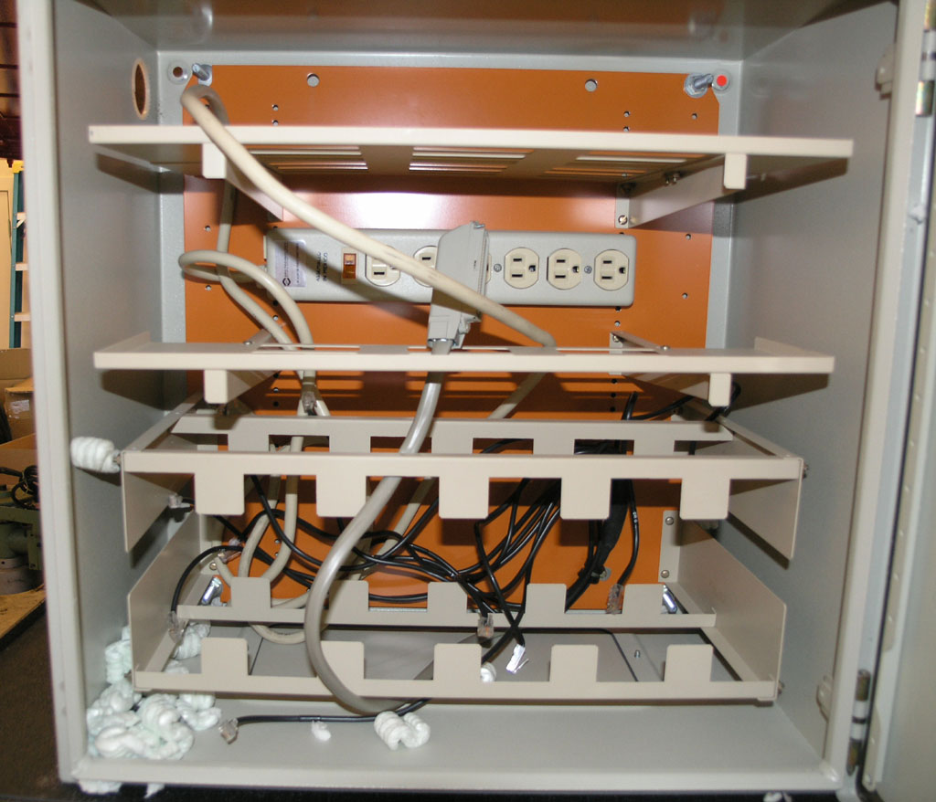 Metal electrical box with multiple outlets, switches, and variously colored wires inside.