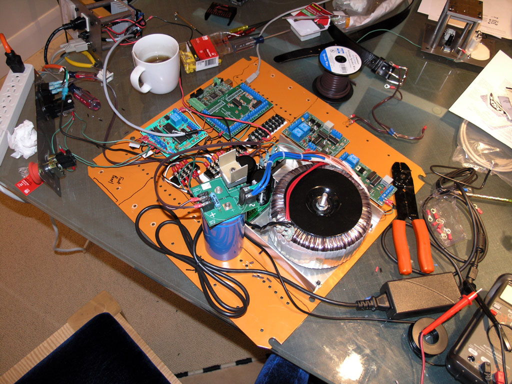 Electronic components on a cluttered glass table.