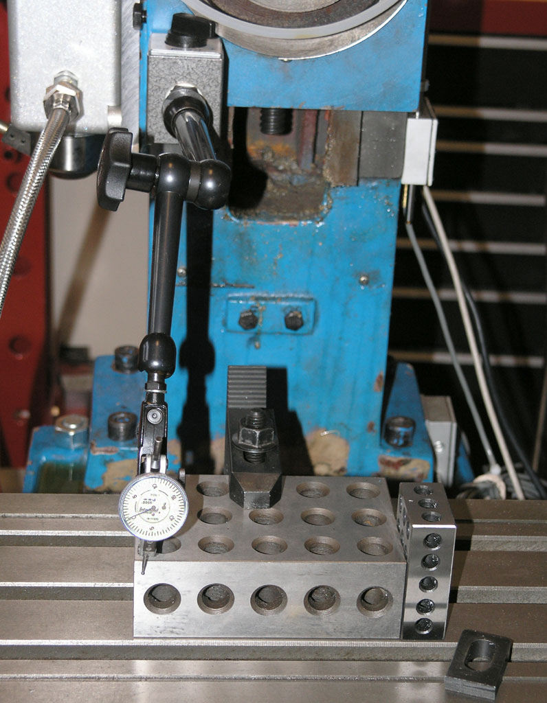 Blue metalworking machine with a dial indicator and gauge device.