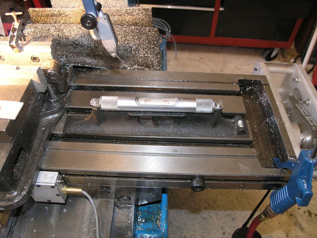 Metalworking lathe with tools and equipment in a workshop.