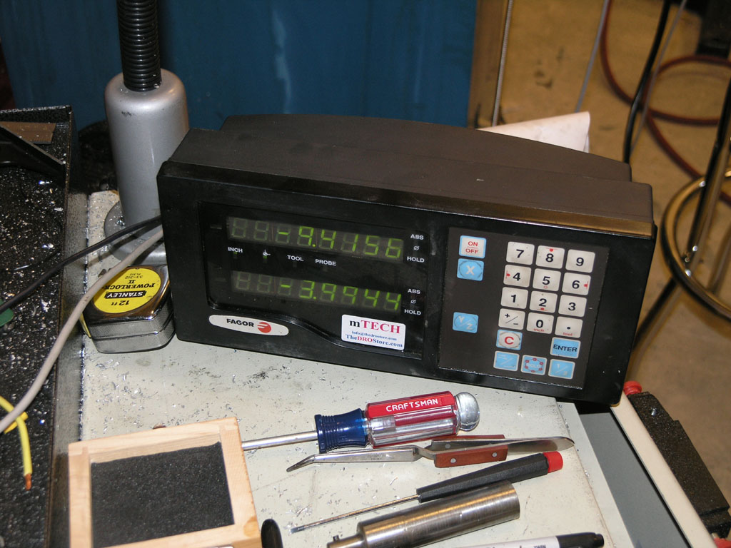 Digital readout device with keypad and display in machine shop or manufacturing setting.