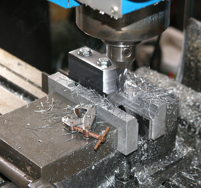 Metalworking machine in operation with large drill bit and metal debris.