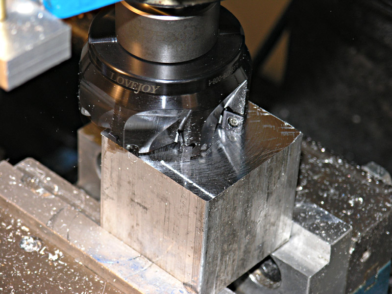 A metalworking tool, likely a milling cutter or drill bit, held in a vise with the text "LOVEJOY" engraved on it.