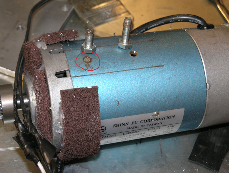Industrial motor with blue casing, brown scrubbing pads, and Shin N F Corporation label.