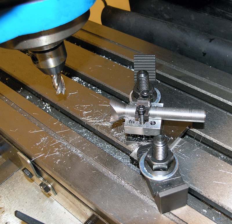Milling machine workpiece with metal shavings and cutting tool.