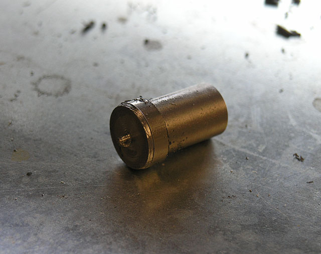 Rough metal cylinder on dirty floor/table.