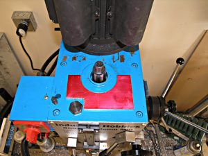 Blue metal workbench with tools and equipment on a beige wall background.