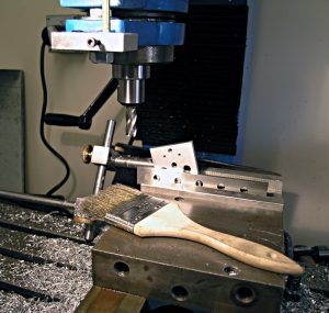 Metalworking drill press with black cord and blue guard on workbench.