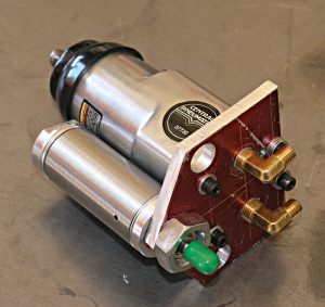 Metal component with silver body, black cap, red base, and green knob.