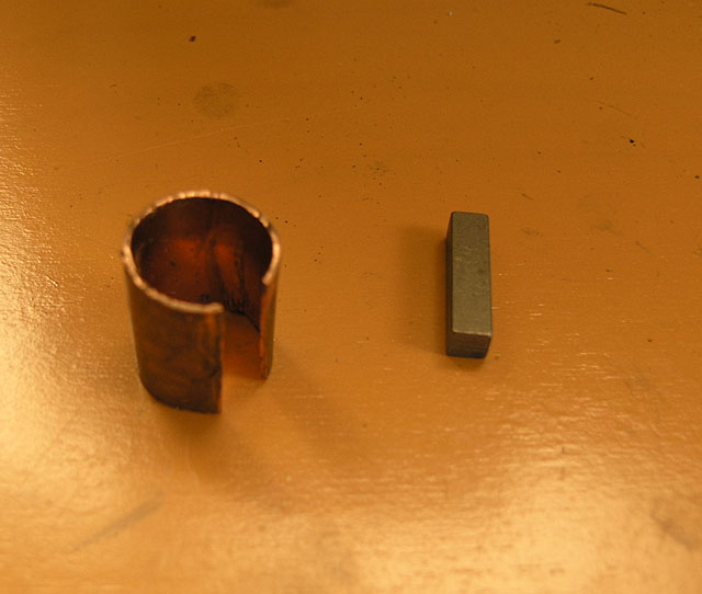 Copper ring on orange surface with metal piece