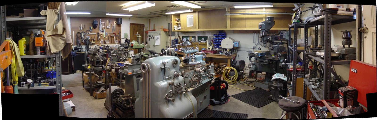 Cluttered workshop with machinery, tools, and storage.