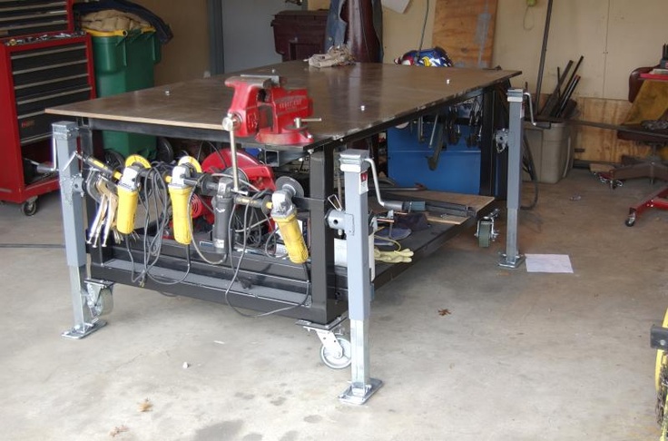 Sturdy workbench with dark top and gray legs, featuring tools and equipment.