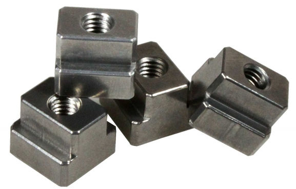 Metal T-slot nuts with threaded centers, used in machining or machine shops.