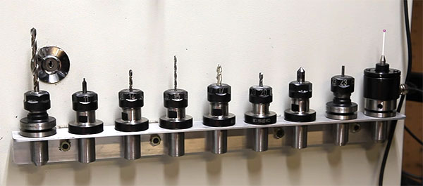 Row of drill bits attached to a metal bracket.