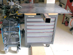 Metal workbench with tools and equipment.