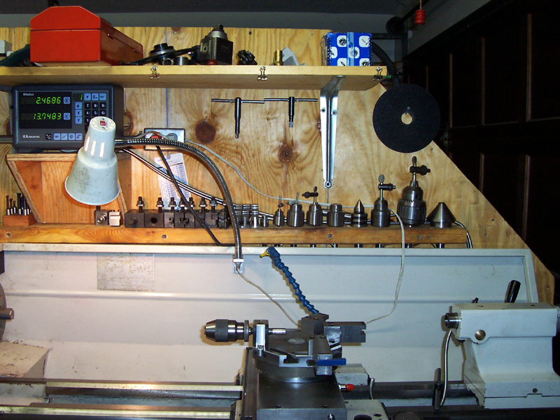 Lathe in workshop with various tools and equipment.