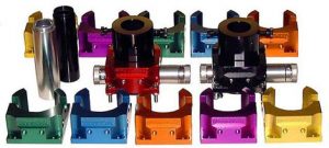 Colored metal parts in various shapes and sizes arranged on a light gray background.