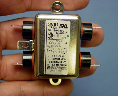 Small electronic component with metal prongs and technical labels.
