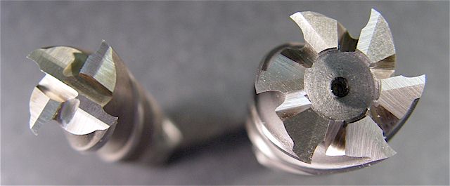 Two end mills with center-cut and non-center-cut cutting edges, shown side by side on a gray surface.