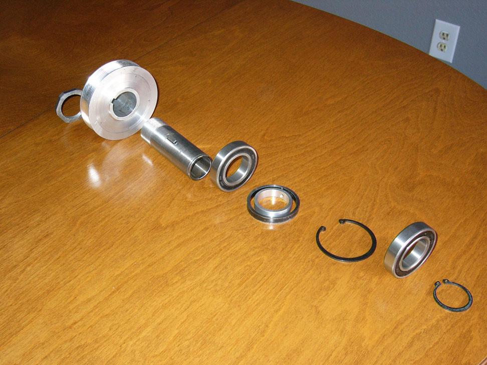 Metal components, including bearings and washers, on a workshop workbench.