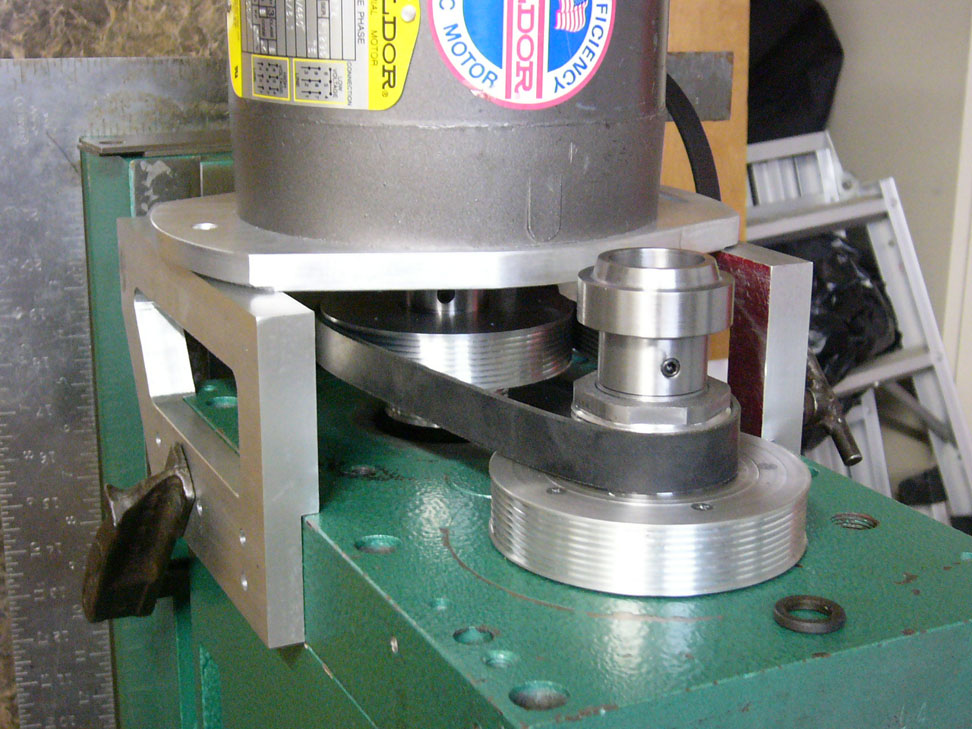 Close-up view of a green metal machine with silver components on a white background.