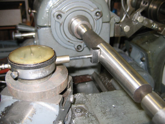 A close-up of a dial indicator on a lathe in a machine shop.