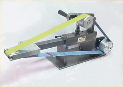 Small metalworking tool with rotating wheel and long handle on a light gray background.