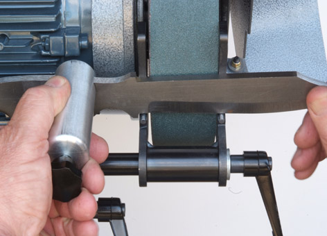 Hand holding a cylindrical tool, possibly from a jig or fixture, used in metal fabrication or CNC machine operation.