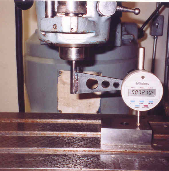 Digital micrometer on metal stand with cylindrical base and round dial.