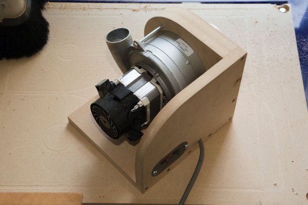 A beige vacuum motor with silver fan and black cord on a rectangular base.