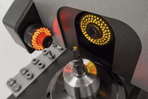 Black and silver inspection machine with red and yellow lights.