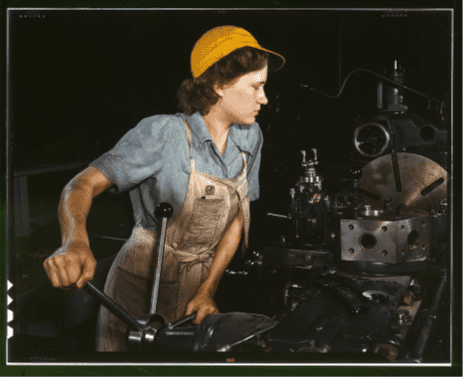 Young woman operating machine with long handle in industrial workshop.