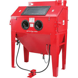 A red metal cabinet with circular openings and a rectangular window, featuring a black power cord.