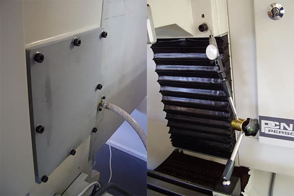 White metal plate with black screws and hose, set against a light-colored background.