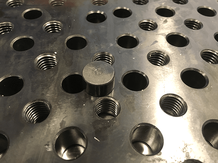 Metal sheet with holes and central disc.